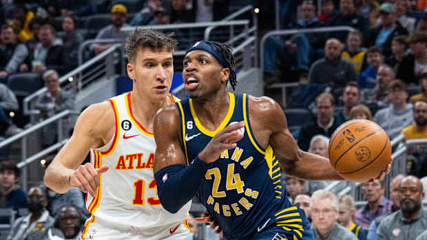 Pacers guard Buddy Hield dribbles past Hawks guard Bogdan Bogdanovic.